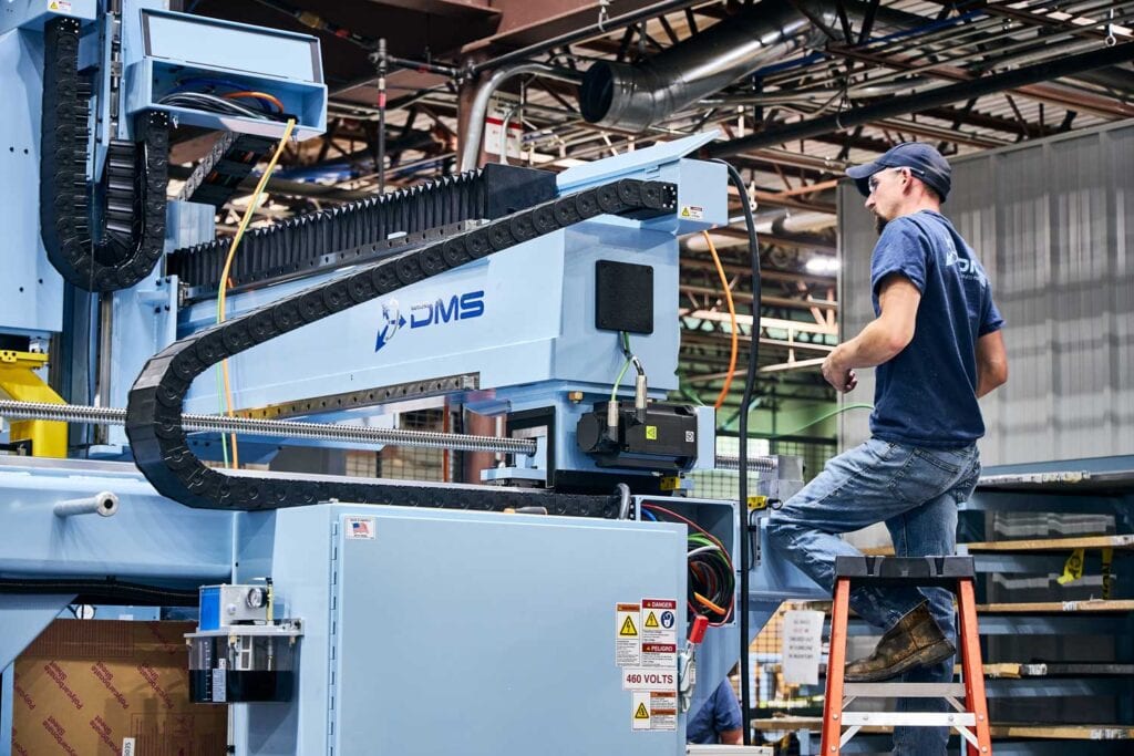 Man on factory floor working on a DMS 5-axis machine