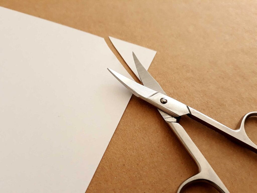 Scissors cutting corners off a page